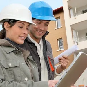 A man and woman at construction site using a tablet indicating how the Manage service provider focuses on the AEC industry (architecture, engineering and construction) through their managed IT services.